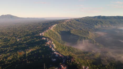 Drone-overview-the-Kintamani-mountain-village,-dreamy-sunrise-in-Bali,-Indonesia