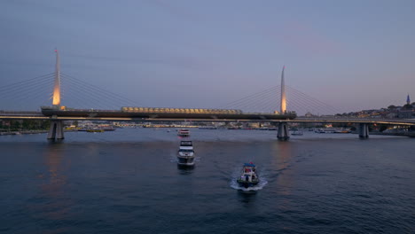 Abends-Fahren-Fähren-über-Die-Beleuchtete-U-Bahn-Brücke-Mit-Goldenem-Horn-In-Istanbul