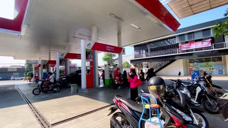 People-refueling-vehicles-at-the-gas-station-pump-and-convenience-store