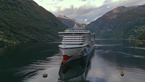 Aerial-of-a-cruise-ship-from-the-AIDA-line-moored-of-the-village-of-Gieranger-at-the-head-of-the-Geirangerfjord,-Norway