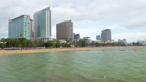 Beachfront-of-Pattaya-facing-the-gulf-of-Thailand,-with-condominiums,-shopping-malls,-apartments,-and-other-business-establishments-in-the-background