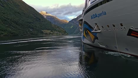 Aerial-of-a-cruise-ship-from-the-AIDA-line-moored-of-the-village-of-Gieranger-at-the-head-of-the-Geirangerfjord,-Norway