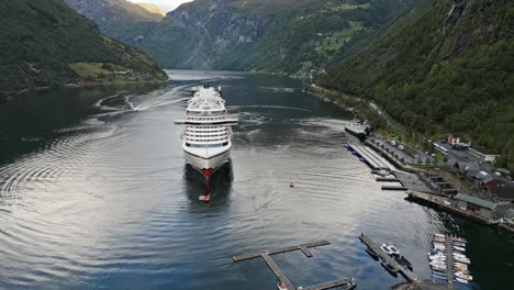 Aérea-De-Un-Crucero-De-La-Línea-Aida-Amarrado-En-El-Pueblo-De-Gieranger-En-La-Cabecera-Del-Fiordo-De-Geiranger,-Noruega