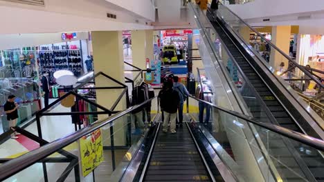 Buyers-walking-down-on-shopping-mall-escalator