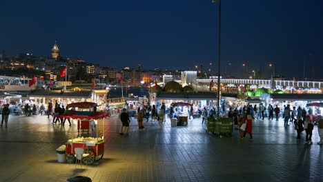 Belebte-Stadtnachtszene-Am-Eminönü-Pier-Mit-Beleuchtetem-Galata-Turm