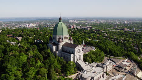 Aerial-view-backwards-away-from-Saint-Joseph's-Oratory,-summer-day-in-Montreal