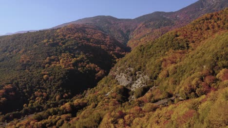 Aerial-view-showing-Autumn-mountains-with-brown-and-orange-color-against-blue-sky-in-Northen-Greece
