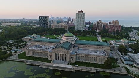 Drone-shot-rising-over-the-Museum-of-Science-and-Industry,-toward-the-Chicago-skyline