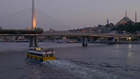 Am-Abend-Fährt-Die-Fähre-Zur-Beleuchteten-U-Bahn-Brücke-Mit-Dem-Goldenen-Horn-In-Istanbul