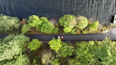 Aerial-following-asphalt-roller-preparing-renewed-countryside-road-by-the-sea