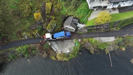 LKW-Füllt-Asphaltverlegemaschine-Mit-Neuem-Asphalt-Auf,-Während-Er-Eine-Schmale-Privatstraße-In-Der-Nähe-Des-Meeres-Erneuert