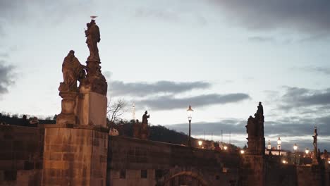 Dämmerung-über-Der-Karlsbrücke-In-Prag-Mit-Statuen-Und-Geschäftigen-Touristen