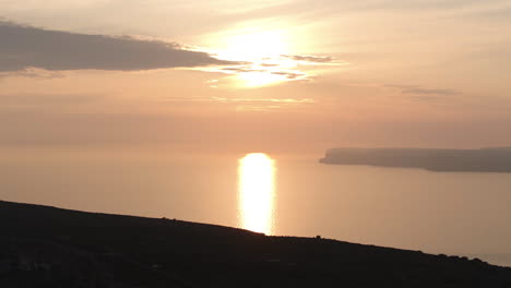 Aerial-telephoto-shot-of-the-sunset-reflecting-from-the-Mediterranean-sea-in-Malta