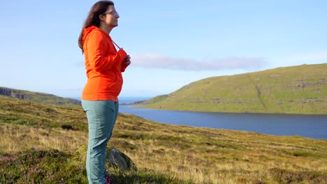 Entspannte-Frau-Auf-Einem-Hügel,-Die-Die-Färöische-Schönheit-Des-Sees-Sorvagsvatn-Bewundert