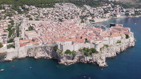 Vista-Aérea-De-Dubrovnik:-Casco-Antiguo,-Mar-Turquesa-Y-Costa-Animada---Grúa-Arriba