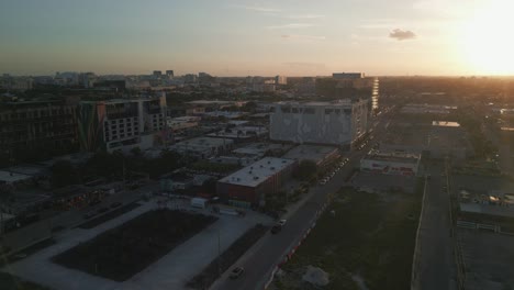 Aerial-of-air-district-Wynwood-at-sunset-with-skyscraper-building-painted