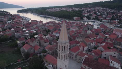 Aerial:-Bell-tower-Church-of-St-Stephen-overlooking-Stari-Grad,-Hvar-Island,-Croatia