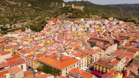 4k-Aerial-of-Bosa-town-in-Sardinia-colorful-houses-flying-forward-above-roofs