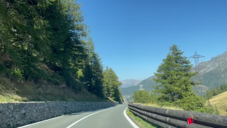 Road-trip-in-northern-Italy,-Aosta-Valley,-driving-along-woods-and-tree-lined-avenues,-in-beautiful-nature-on-a-late-summer-day