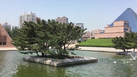 Denkmal-Im-Longhua-Gardens-Park-In-Der-Nähe-Des-Märtyrerdenkmals-In-Shanghai,-China-Mit-Einem-Baum-In-Einem-Wasserbecken,-Schwenk