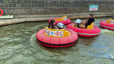 Niños-Jugando-En-Botes-Chocones-En-El-Agua-En-Un-Parque-Temático-De-Vacaciones