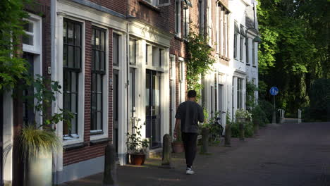 Ein-Junger-Mann-Geht-Die-Leere-Spieringstraat-In-Gouda,-Südholland,-Niederlande-Entlang