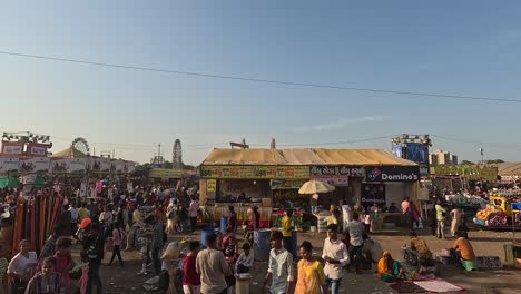 During-the-day-people-are-roaming-around-the-amusement-park-and-enjoying-the-food-stalls-and-drink-stalls