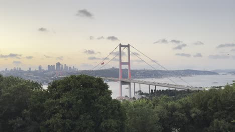 Istanbul-Bosphorus-Bridge-at-golden-hour,-soft-pastel-sky-glows-as-traffic-rushes-across