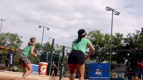 Frau-In-Shorts-Spielt-Padel-Spiel-Auf-Sonnigem-Strandplatz,-Schnelles-Gameplay,-Zeitlupenaufnahme