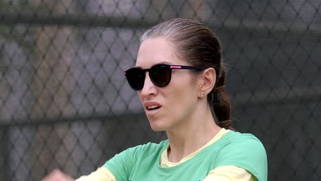 Mujer-Estirando-Los-Brazos-De-Cerca,-Preparándose-Calentando-Antes-Del-Entrenamiento-Del-Partido-De-Pádel,-Usando-Gafas-De-Sol