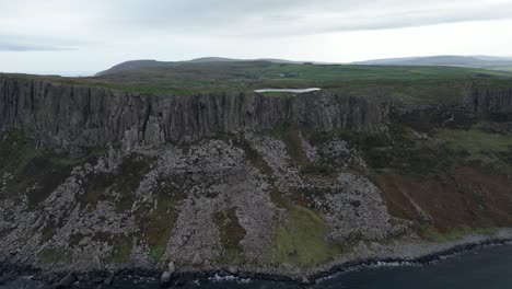 Backwards-dolly-aerial-view-of-the-geographically-prominent-Fair-Head-in-Northern-Ireland-known-for-its-stunning-coastal-cliffs-and-panoramic-views-for-hikers-and-climbers-in-the-early-morning