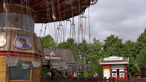 Carrusel-De-Paseo-En-Columpio-Que-Comienza-A-Girar-Llevando-A-Muchas-Personas-Felices---Parque-De-Atracciones-Djurs-Dinamarca