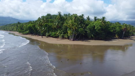 Aerial-view-over-beach-with-a-few-tourists-walking-around-the-sandy-shore-in-Parque-national-Marino-Bellena