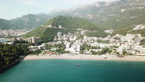 high-angle-aerial-drone-rotating-around-Bečići-town-in-the-municipality-of-Budva,-Montenegro-beach-resort-town-in-Adriatic-Sea-coastline