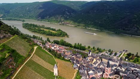 Bacharach-german-town-in-middle-Rhine-Valley-with-its-timbered-medieval-houses-and-vineyards-overlooking-waterway-transportation-barge-ships