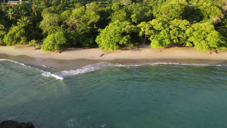 Aerial-view-of-rocky-remote-tropical-beach-in-National-park-of-Manuel-Antonio-in-Costa-Rica-during-sunset