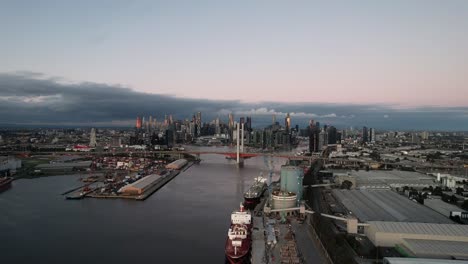 Luftaufnahme-Des-Yarra-River-In-Richtung-Bolte-Bridge,-Skyline-Von-Melbourne-In-Der-Dämmerung