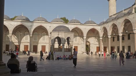 Man-agitated-paces-when-making-cell-phone-call-in-mosque-courtyard