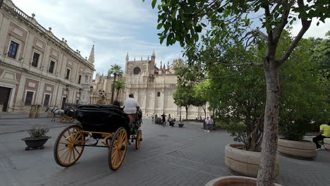 Slowmo-Aufnahme-Eines-Streitwagens-Mit-Vorbeifahrenden-Touristen-Im-Atrium-Der-Kathedrale-Von-Sevilla