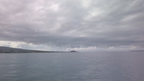 Gimbal-wide-panning-POV-shot-from-a-moving-boat-of-Haleakala-and-Wailea-from-Molokini-Crater-on-the-island-of-Maui,-Hawai'i