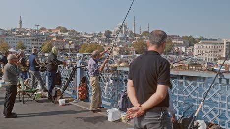 Pescadores-En-El-Puente-De-Gálata-Con-El-Horizonte-De-Estambul-Como-Telón-De-Fondo-En-Cámara-Lenta.
