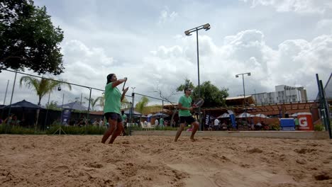Back-hand-and-fore-hand-strokes-being-played-as-mixed-doubles-beach-tennis-team-plays-on