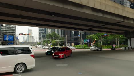 Vehículos-Que-Cruzan-La-Intersección-Rama-9-En-El-Distrito-De-Negocios-Del-Centro-De-Bangkok,-Tailandia