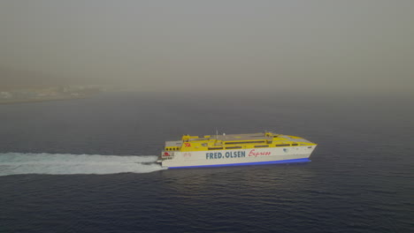 aerial-view-with-lateral-tracking-and-with-an-approach-to-a-ferry-that-sails-on-a-day-with-a-lot-of-haze-in-the-atmosphere