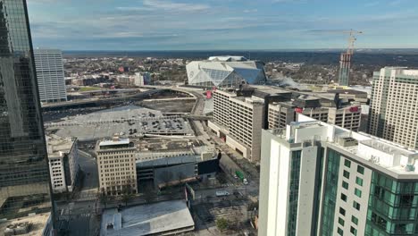 Aerial-forward-flight-over-intersection-with-traffic-in-New-York-City-beside-CNN-Building-and-Mercedes-Benz-Stadium---descending-drone-flyover