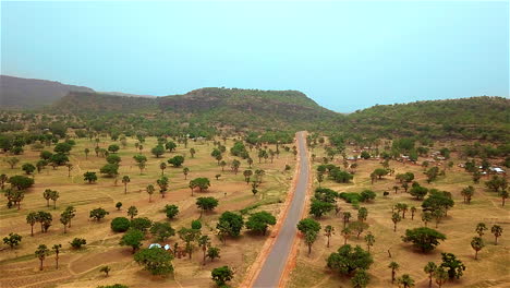 Rural-village-Road-in-Nigeria,-West-Africa---aerial-reveal
