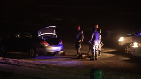 Police-men-arresting-culprits-after-a-car-chase-with-hostages-on-the-floor-and-the-car-boots-being-searched