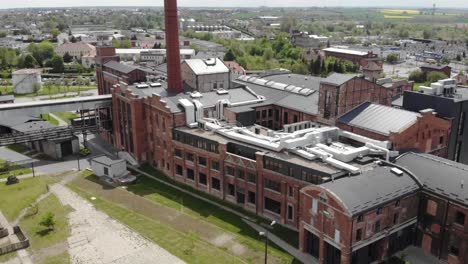 Aerial-tilt-down-shot-of-the-chimney-in-Arche-Hotel-Żnin-inside-old-sugar-factory-in-Poland