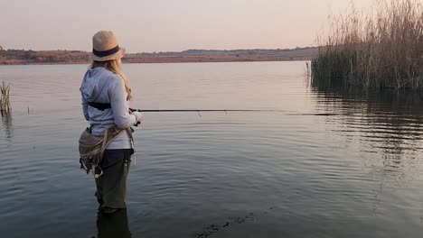 A-beautiful-girl-catching-a-fish-in-a-calm-African-lake