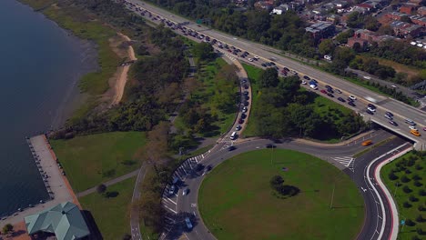 An-aerial-time-lapse-of-the-heavy-traffic-on-the-Belt-Parkway-and-the-the-shores-of-Jamaica-Bay-on-a-sunny-day-in-Brooklyn,-NY